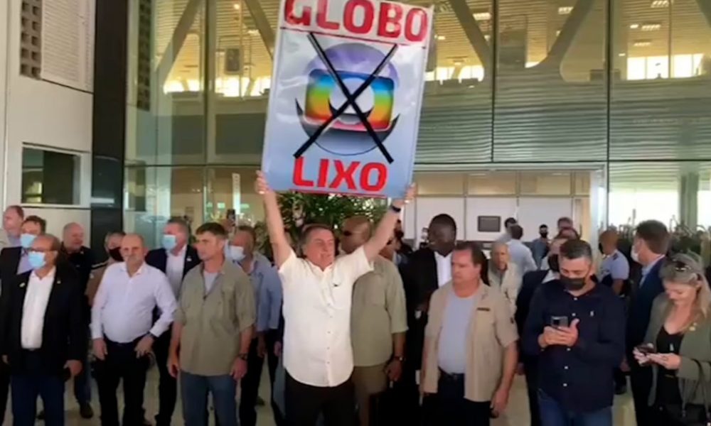  Bolsonaro exibe a apoiadores cartaz com a frase “Globo lixo”, no Paraná