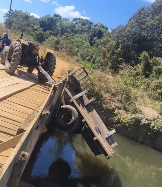 Na área rural de Costa Marques, trator perde força em ponte e carga de telhões cai dentro do rio